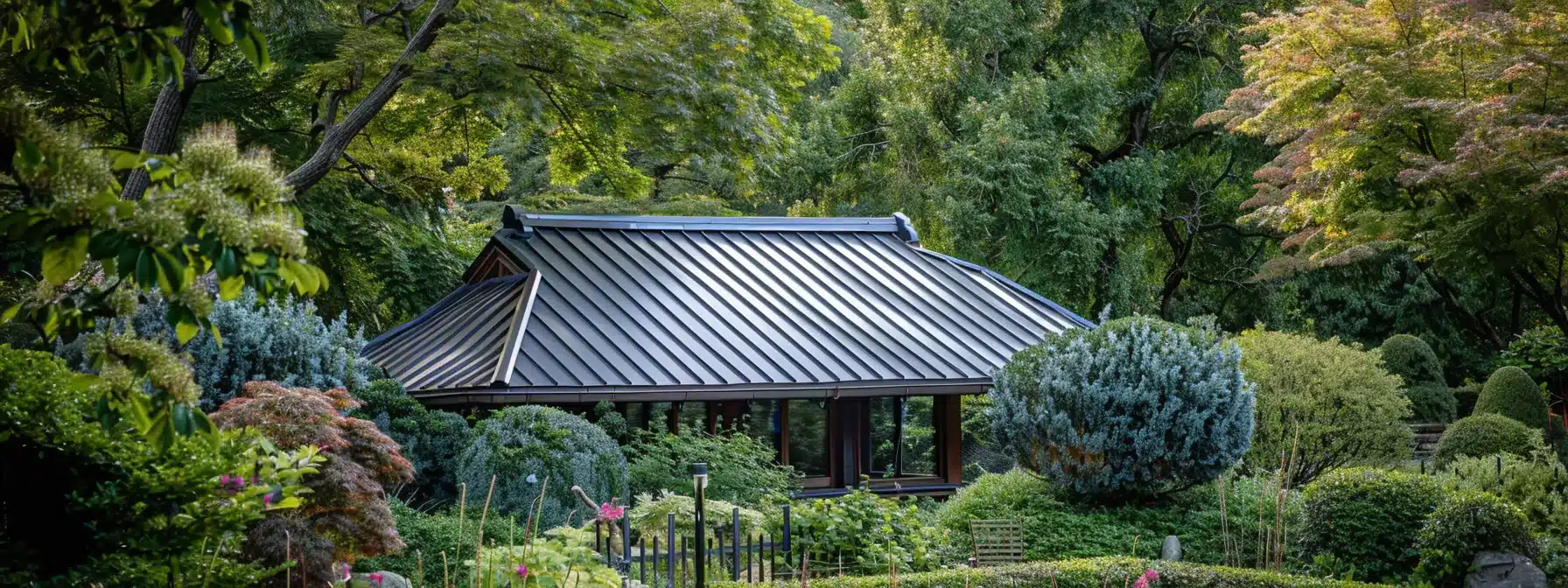 a metal roof surrounded by a well-maintained garden featuring protective barriers and trimmed trees to prevent tree-related damage.